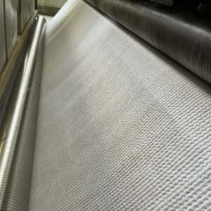 Close-up of sodium bentonite waterproof blanket – needle-punched geotextile layers with gray bentonite powder visible between them